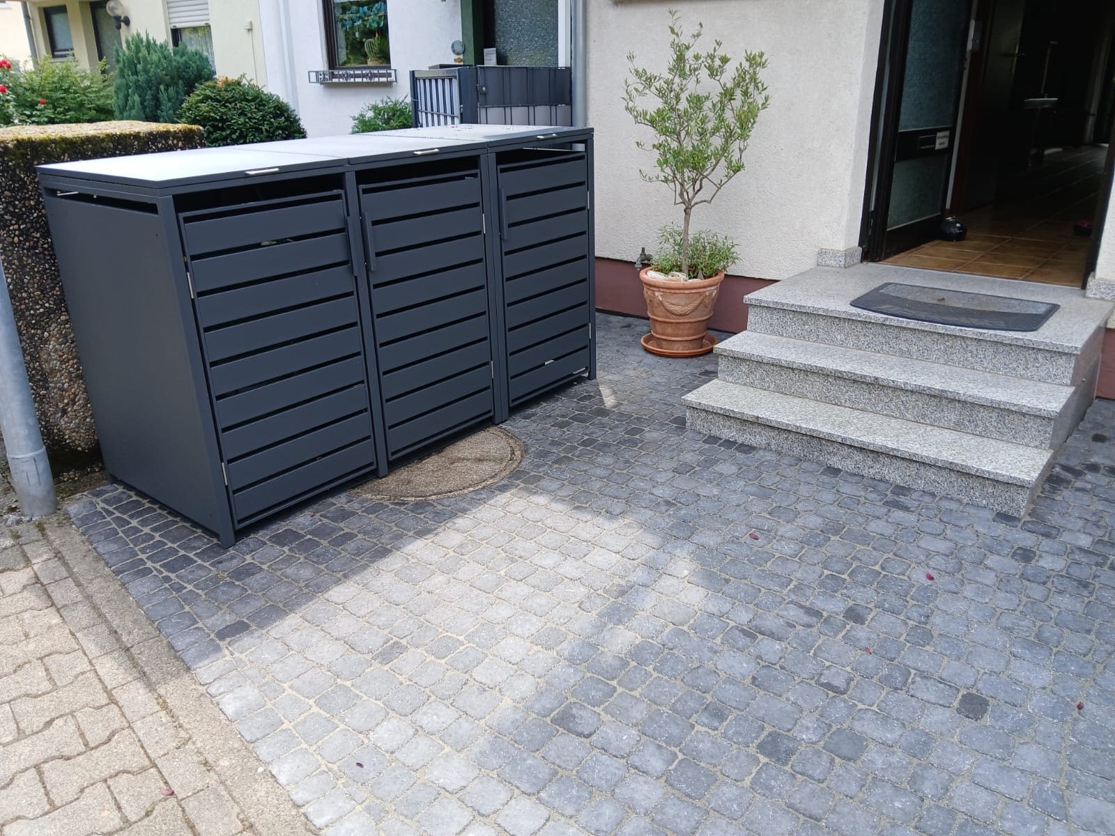 Neue Pflasterfläche mit Mülltonnenverkleidung und Treppe am Hauseingang, Kunde aus Weinheim