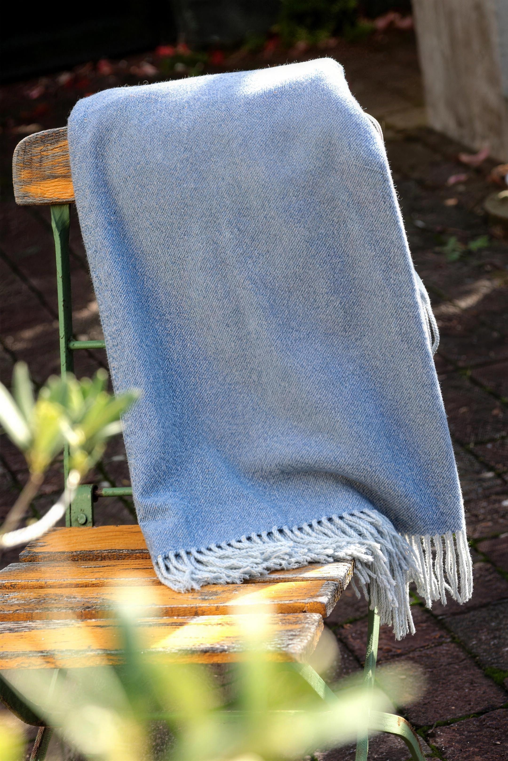 Wolldecke mit Fransen über einem Gartenstuhl